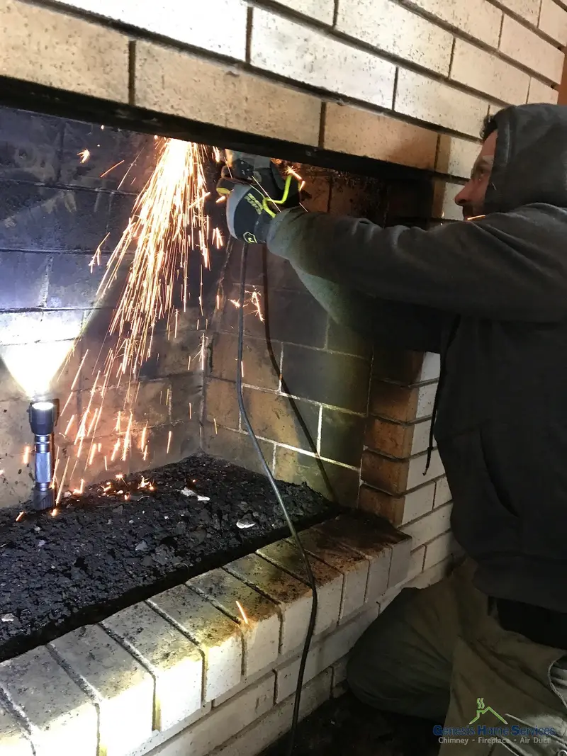 Genesis technician grinding firebox during chimney repair — Seattle WA