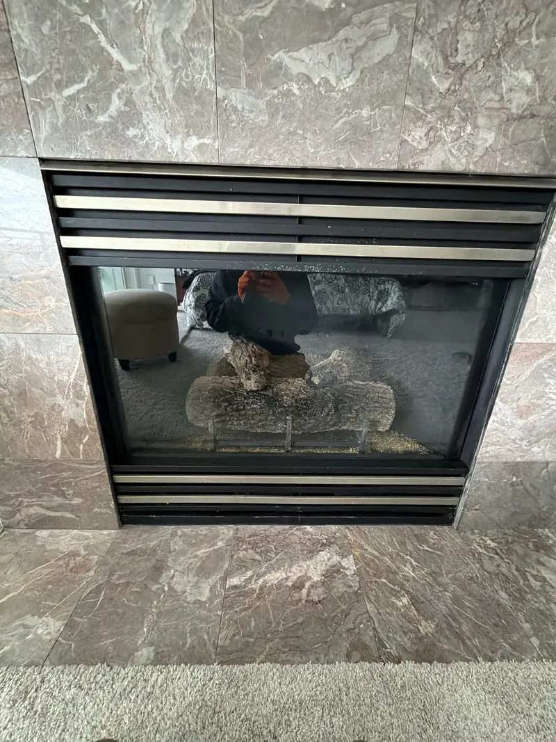 Double-sided gas fireplace dark marble surround — Issaquah