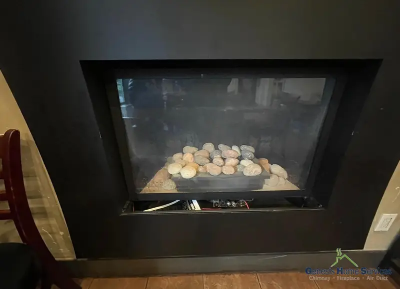Modern black gas fireplace insert with river rock surround installation