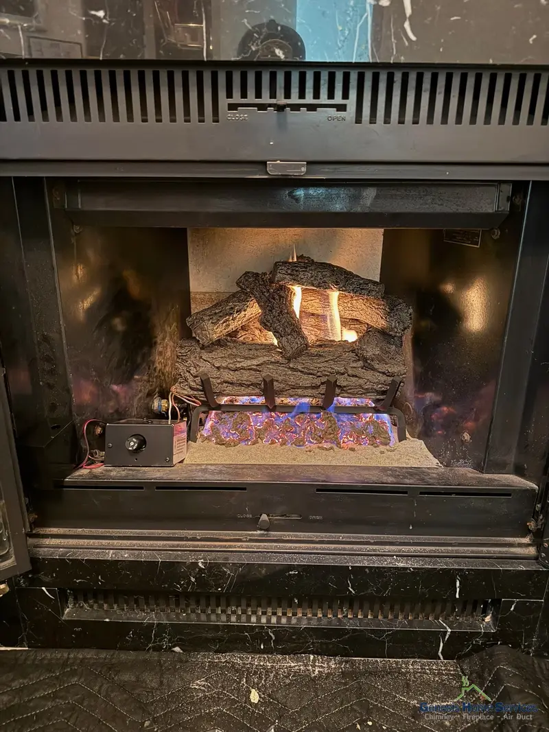 Gas fireplace blue flame logs closeup after repair — Lake Stevens